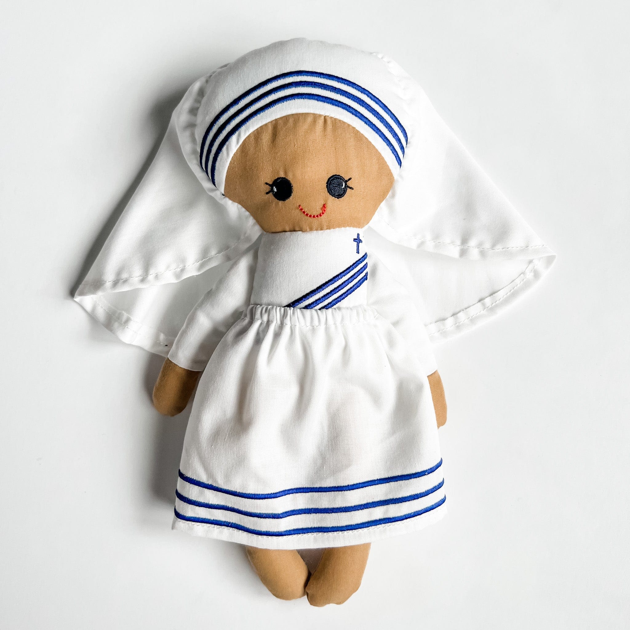 Doll of a woman in a white habit with blue trim.