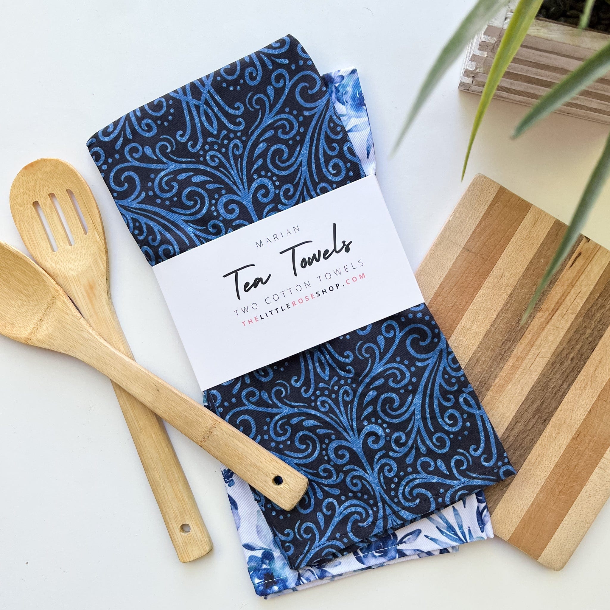 Blue floral tea towels with wooden spoons and cutting board