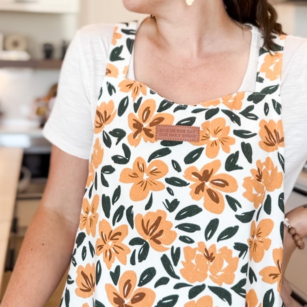 Woman wearing floral apron.