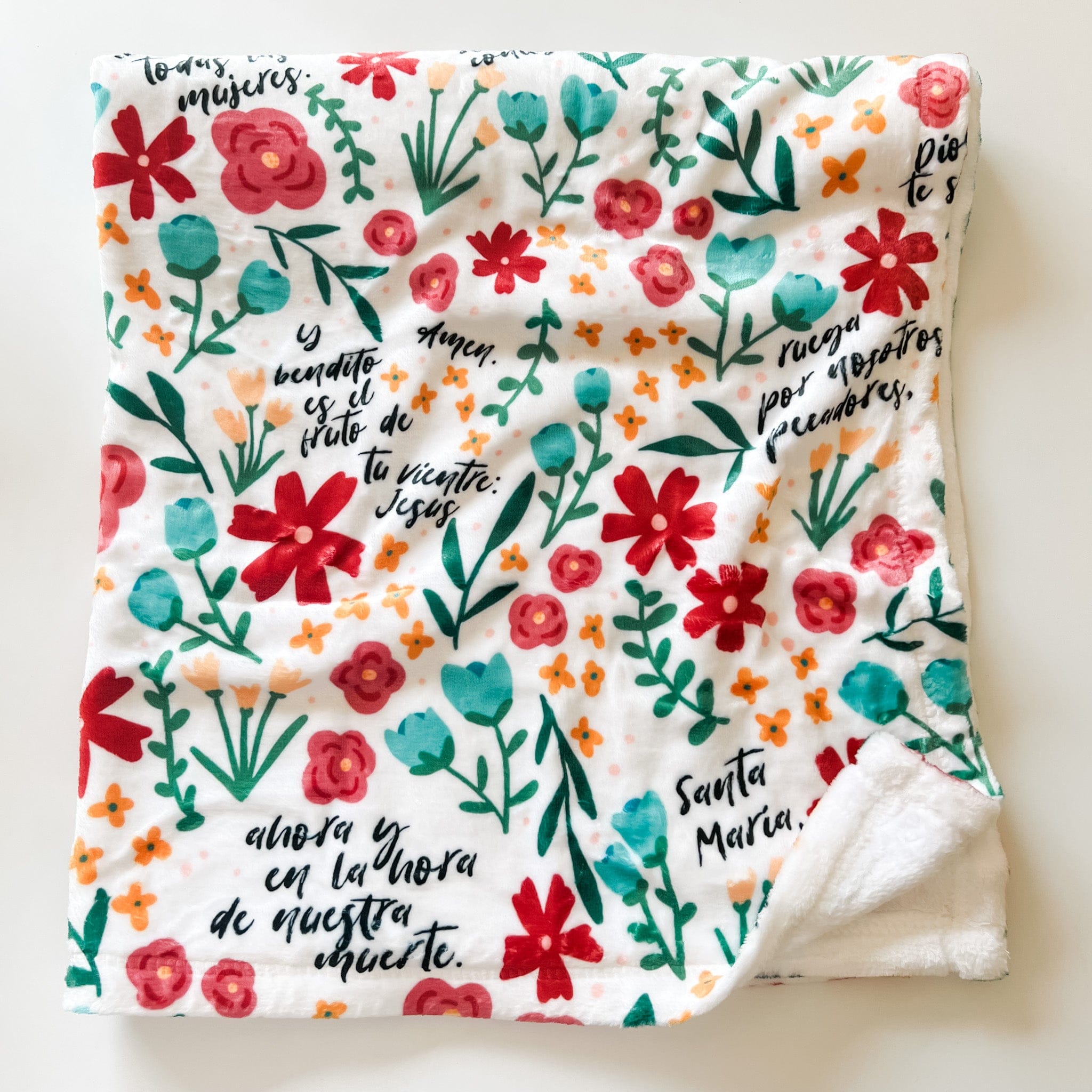 Floral blanket with Spanish text.