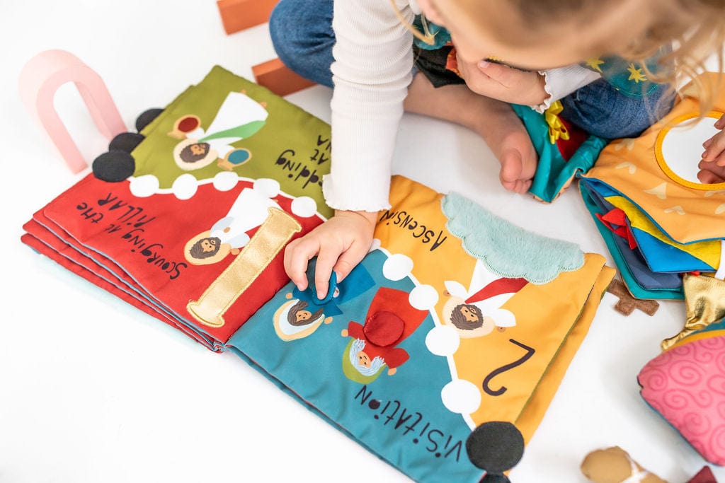 Child playing with colorful educational cloth book