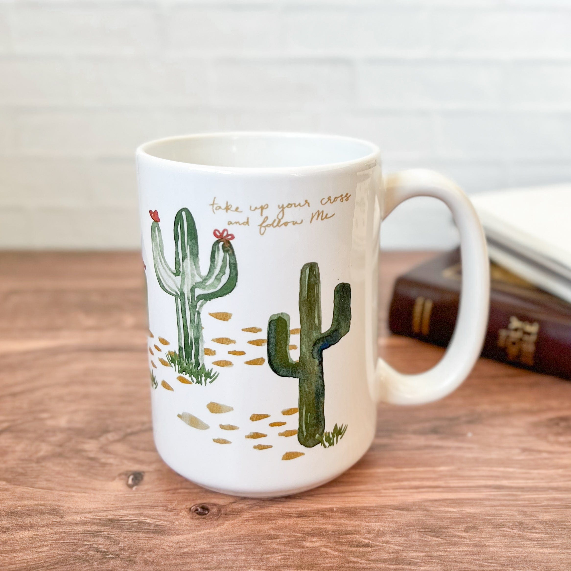White mug with cactus illustration.
