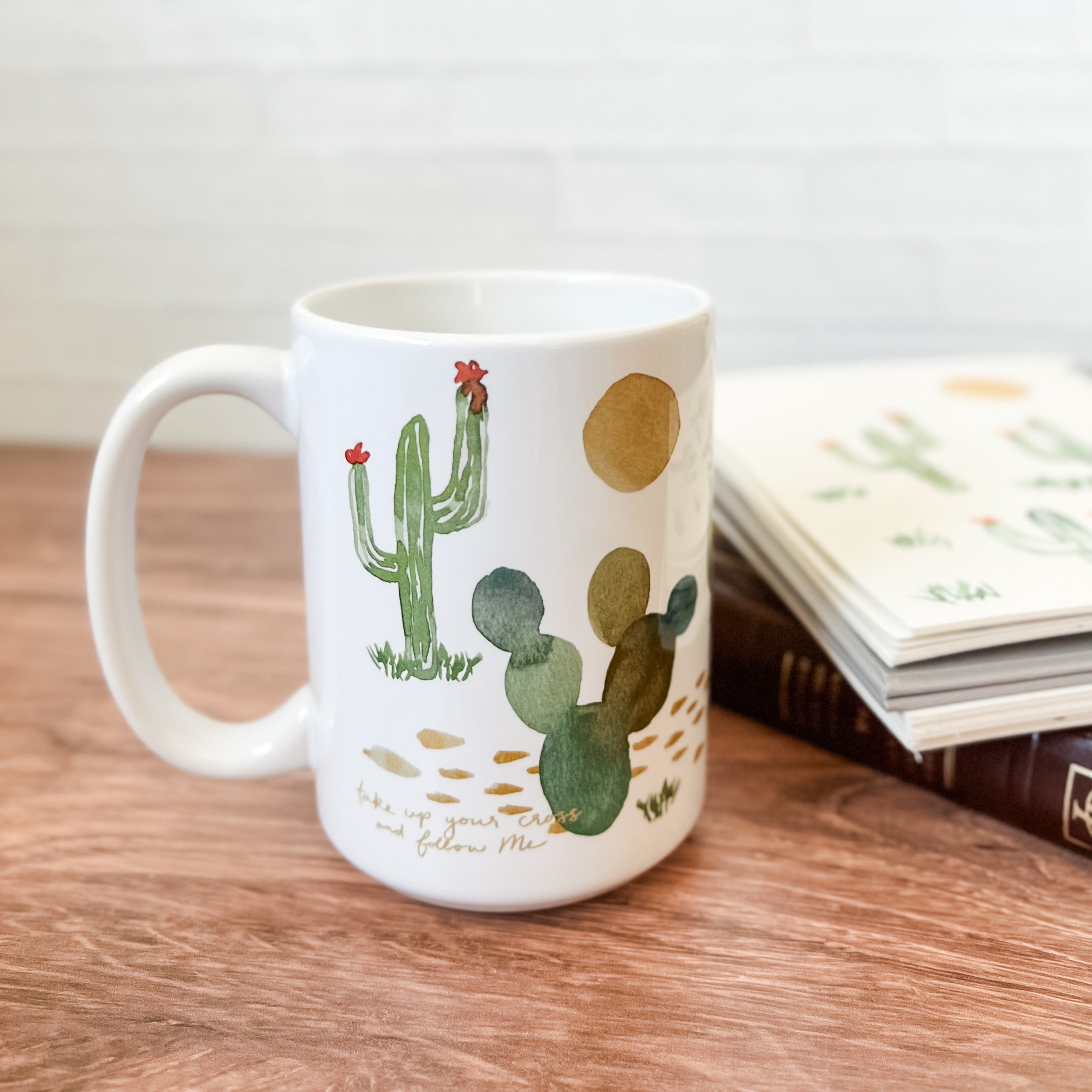 White mug with cactus illustration and book.