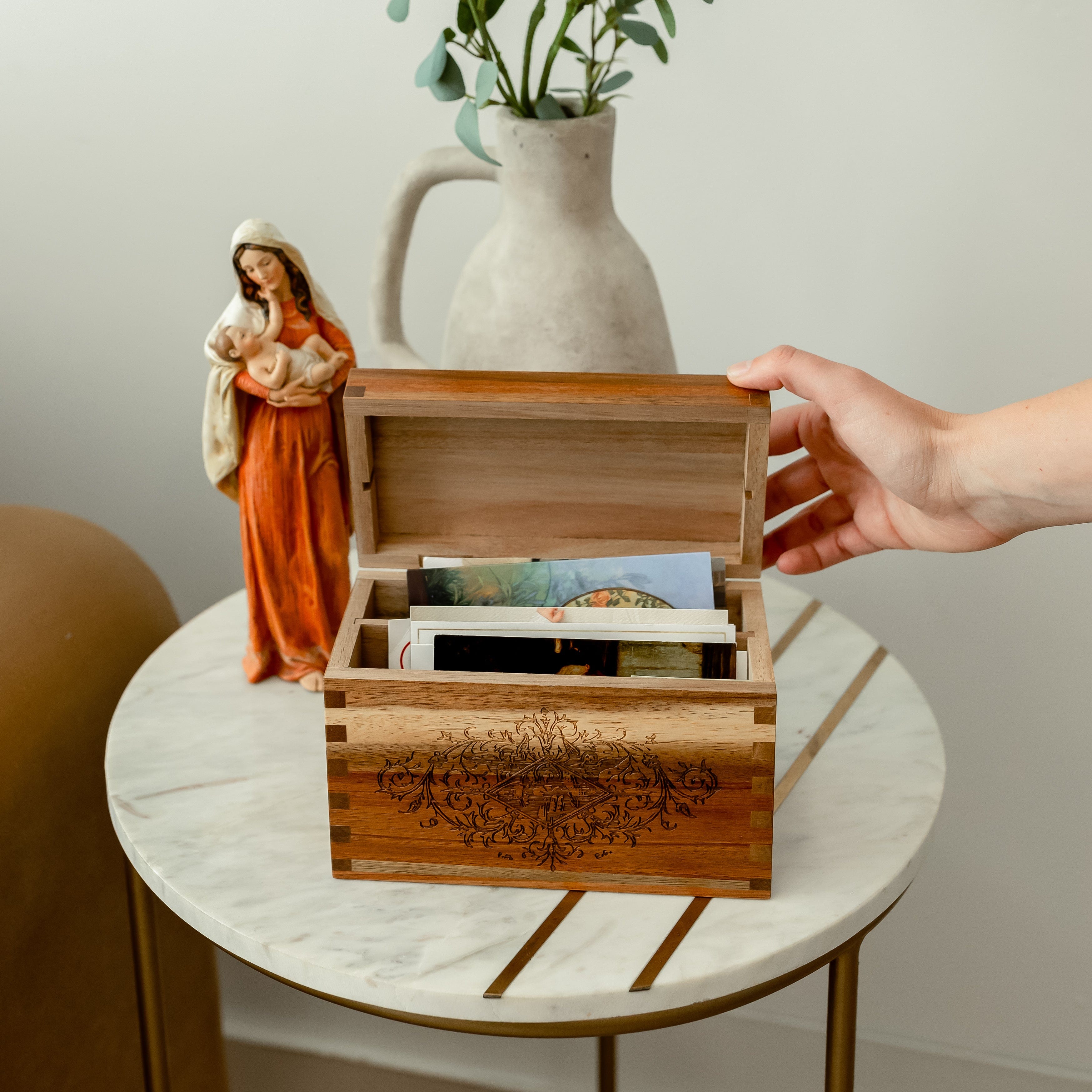 Prayer card box on table with hand reaching