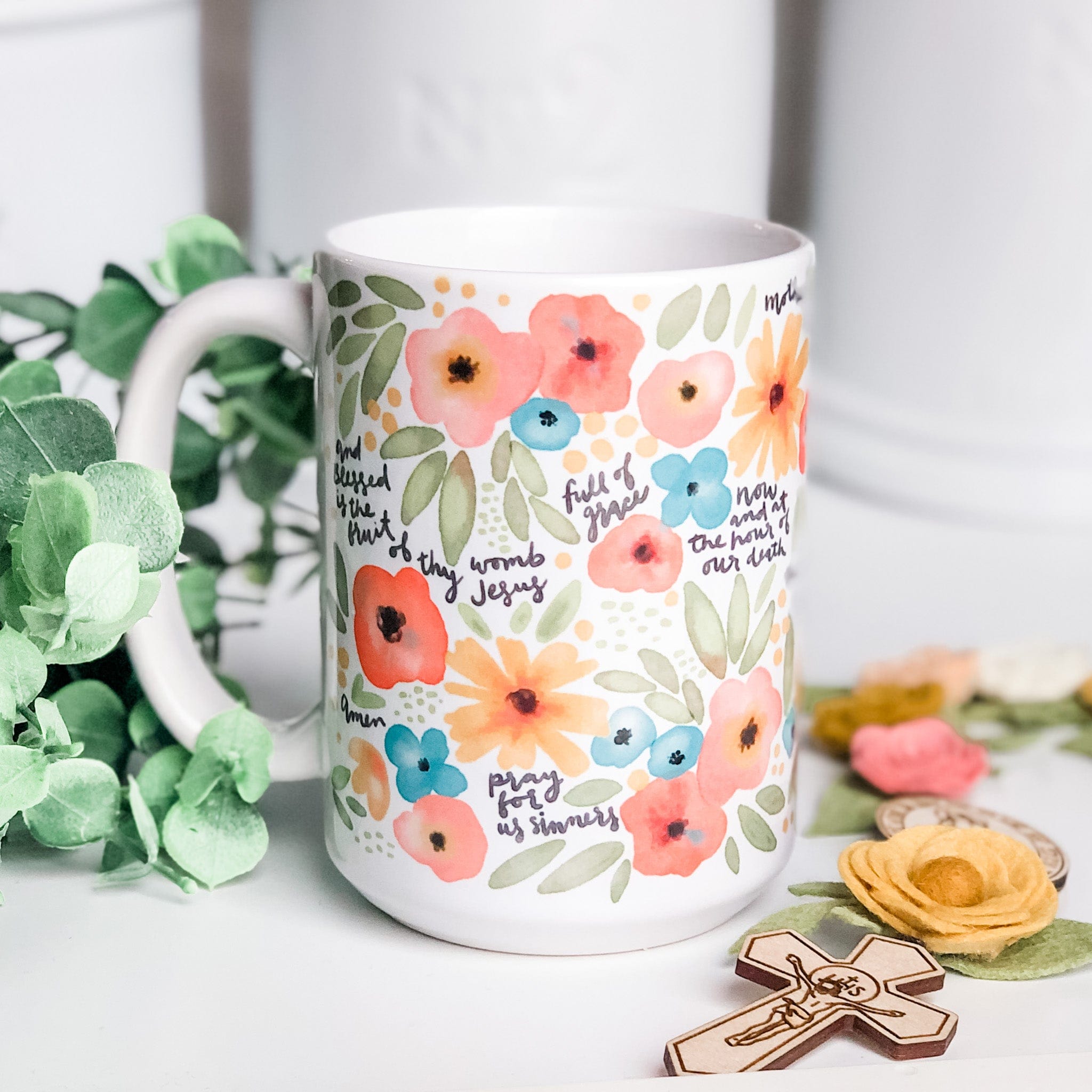 Floral mug with religious text.
