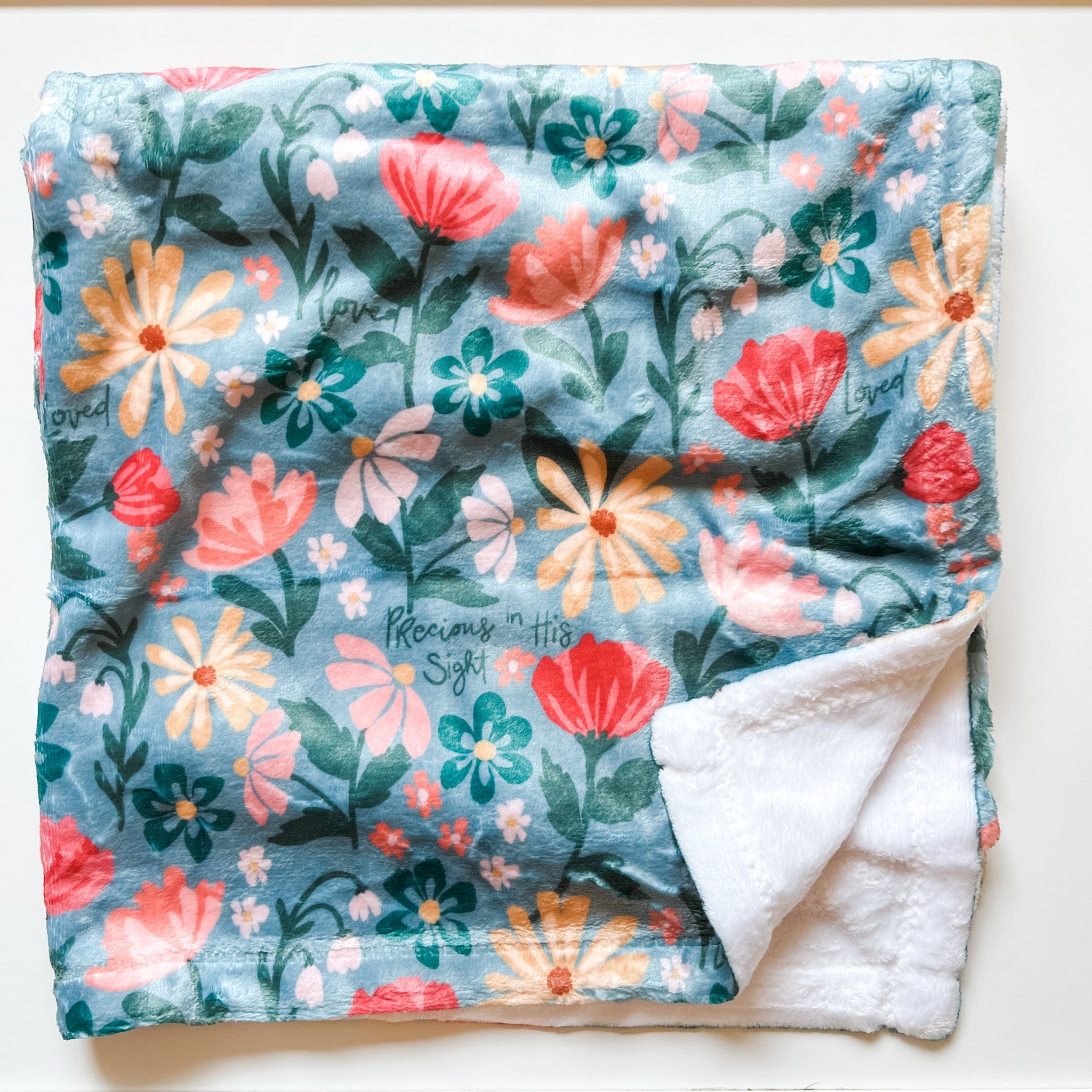 Floral blanket with white fleece trim.