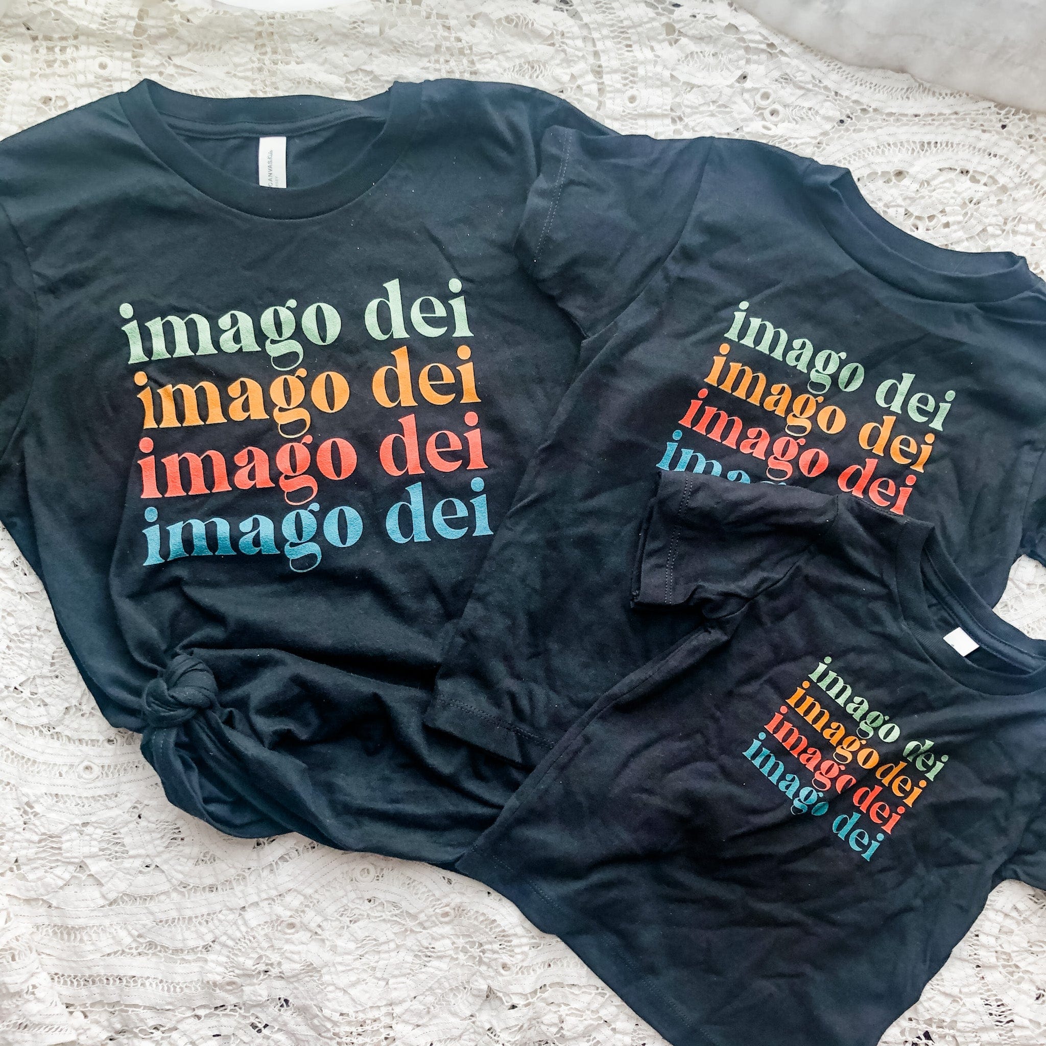 Three black t-shirts with imago dei text.