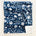 Navy blanket with white floral pattern and text.