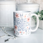 White mug with floral design and text.