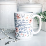 White mug with floral design and text.