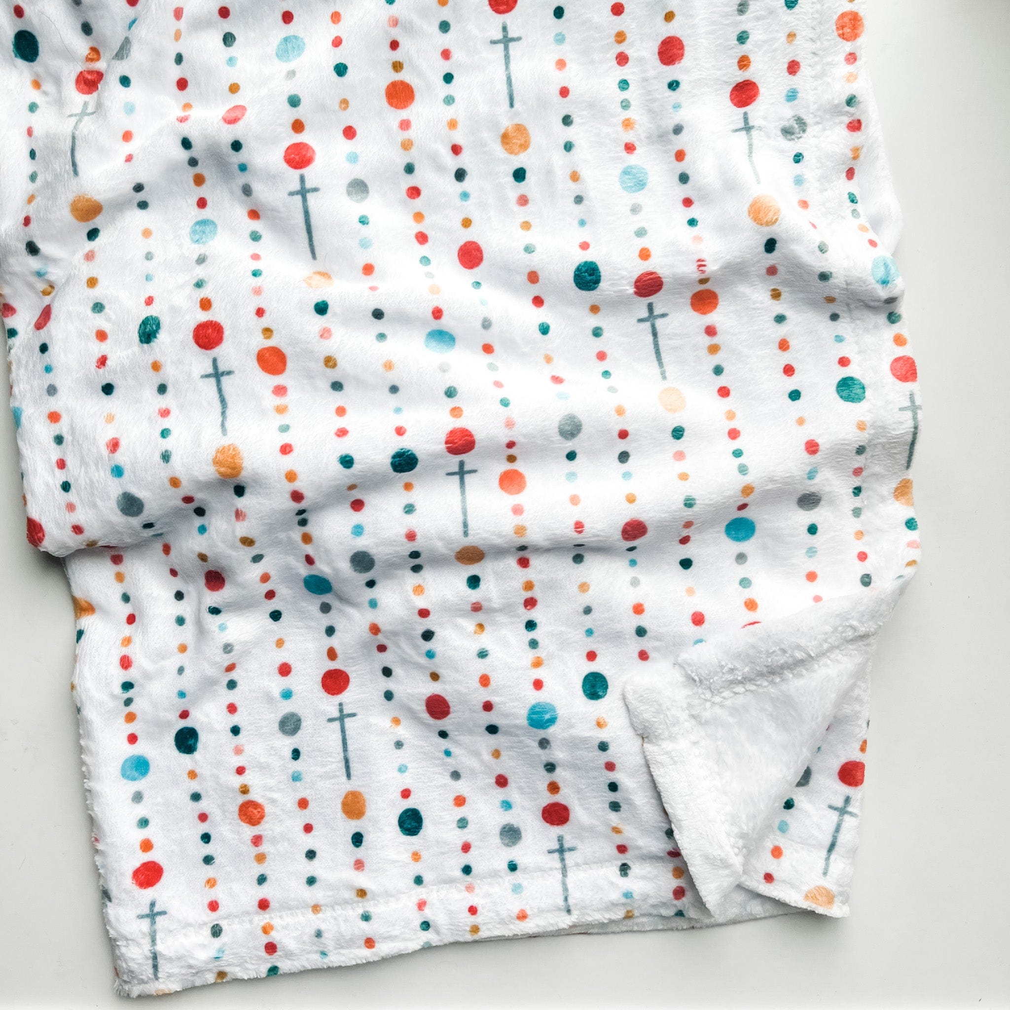 White fabric with colorful dots and crosses.