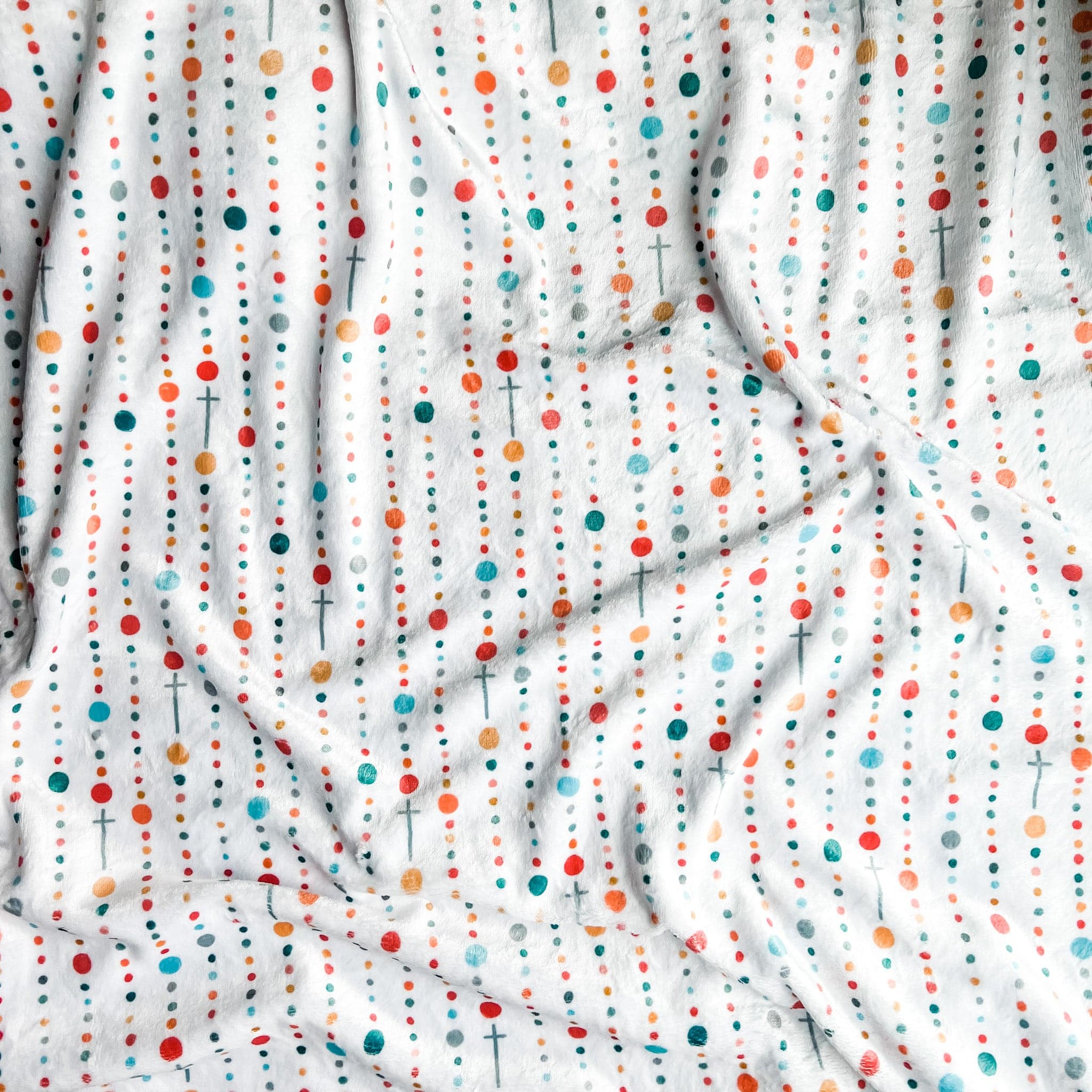 White fabric with colorful dot and cross pattern.