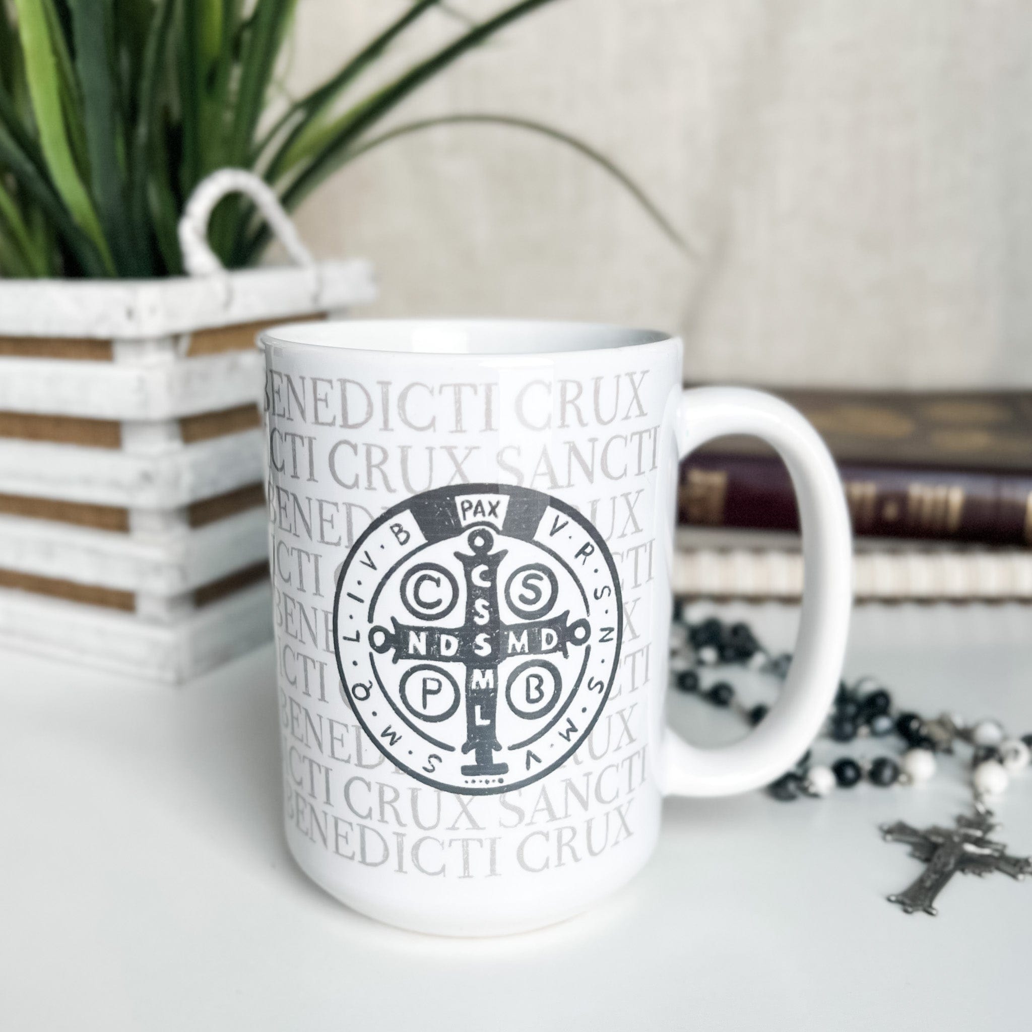 White coffee mug with Saint Benedict medal design.