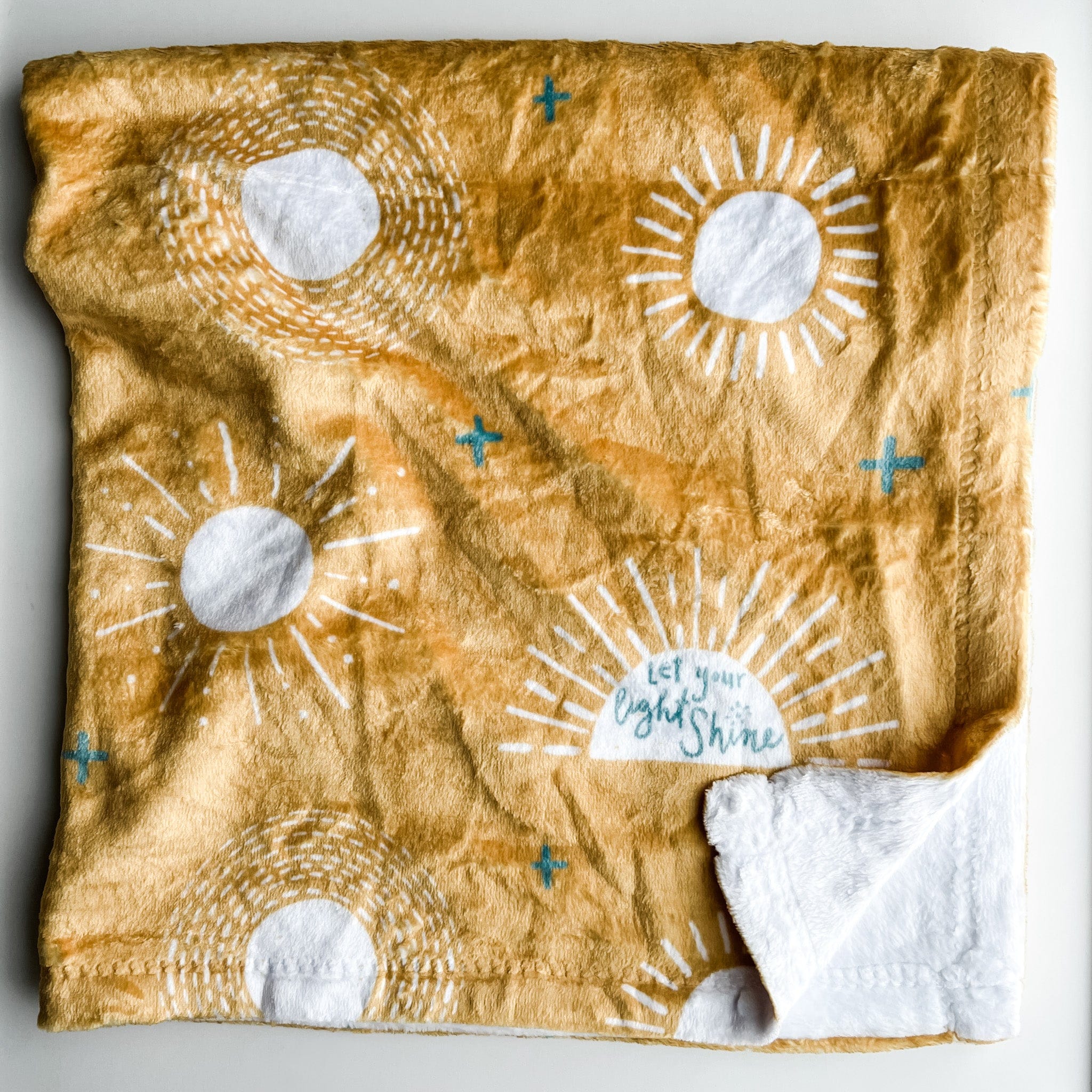 Yellow blanket with sun and star pattern.