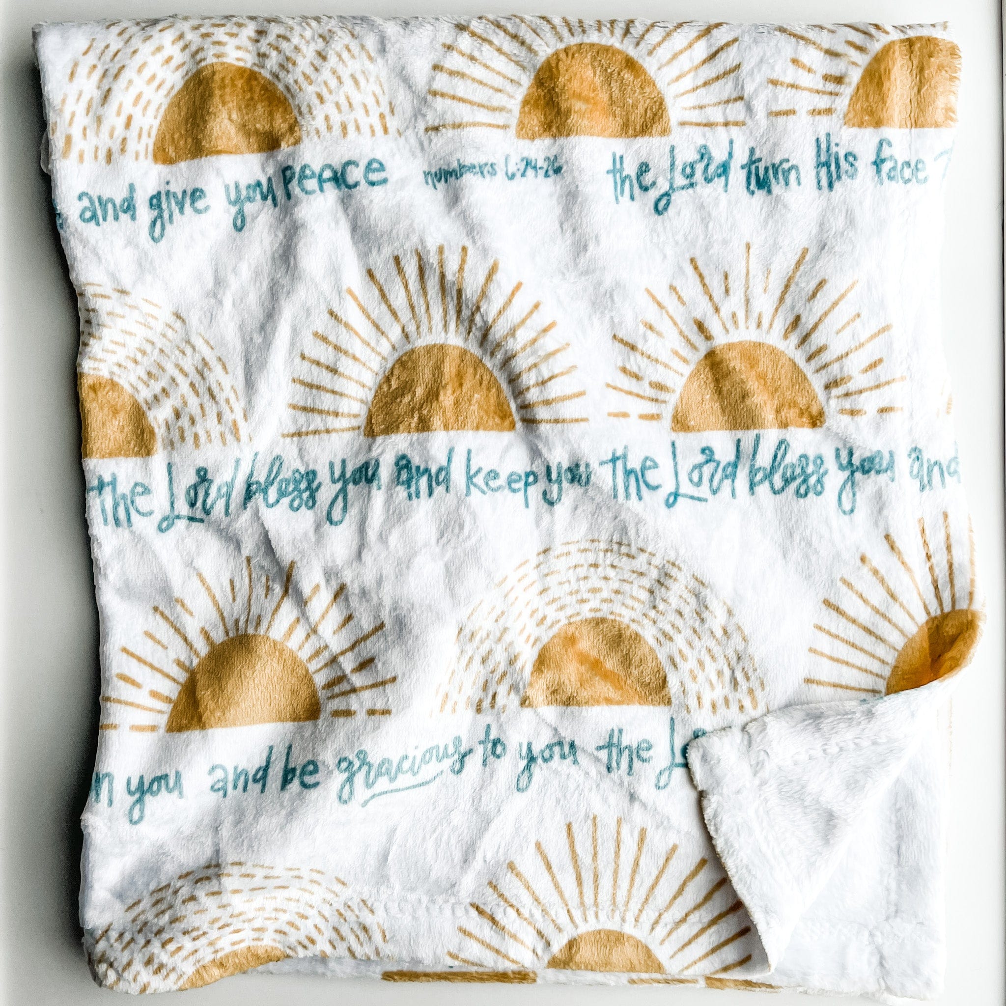 White cloth with gold sunburst pattern and script.