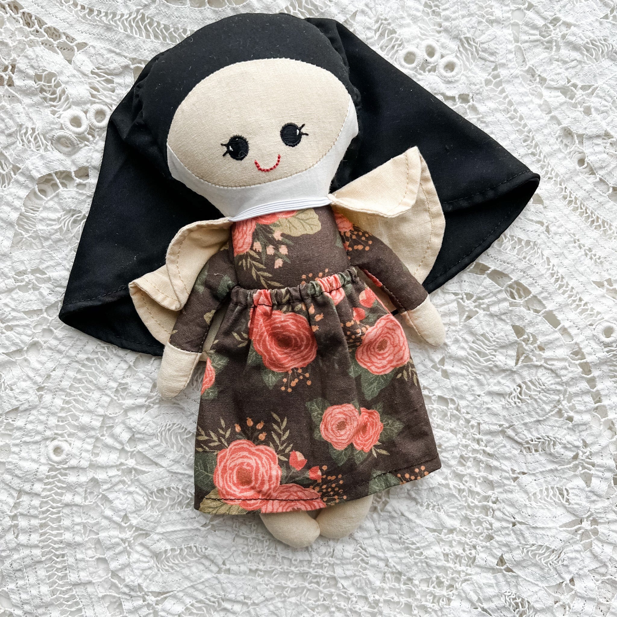 Doll dressed as a nun with floral print dress.