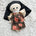 Doll dressed as a nun with floral print dress.