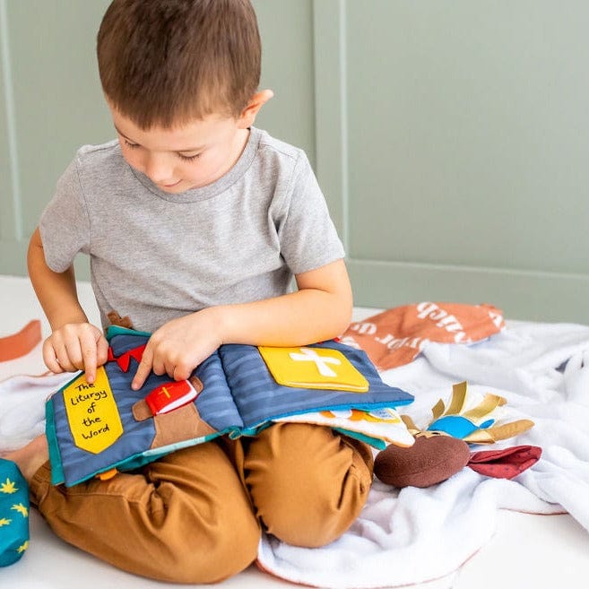 Boy reading a colorful, cloth book.