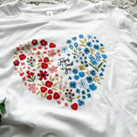 White t-shirt with floral heart design.