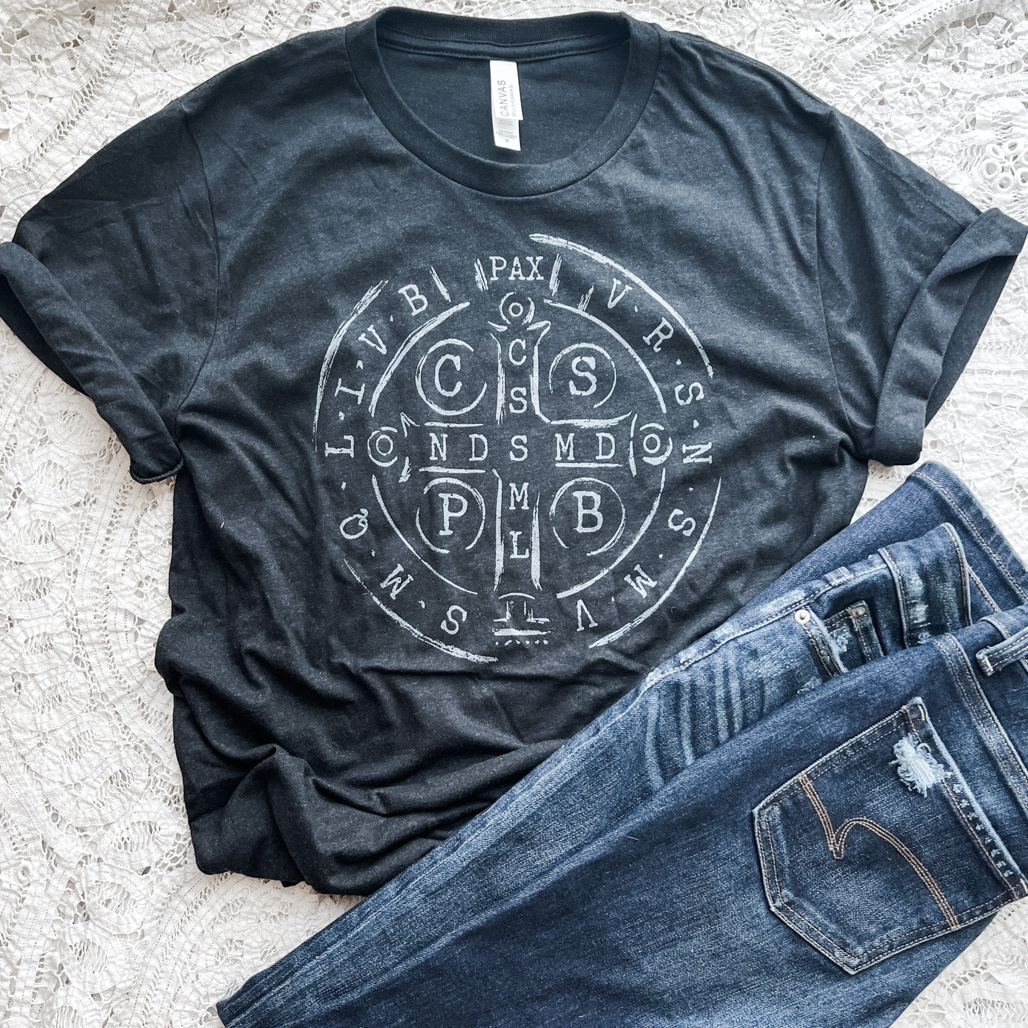Black t-shirt with a circular design and jeans.