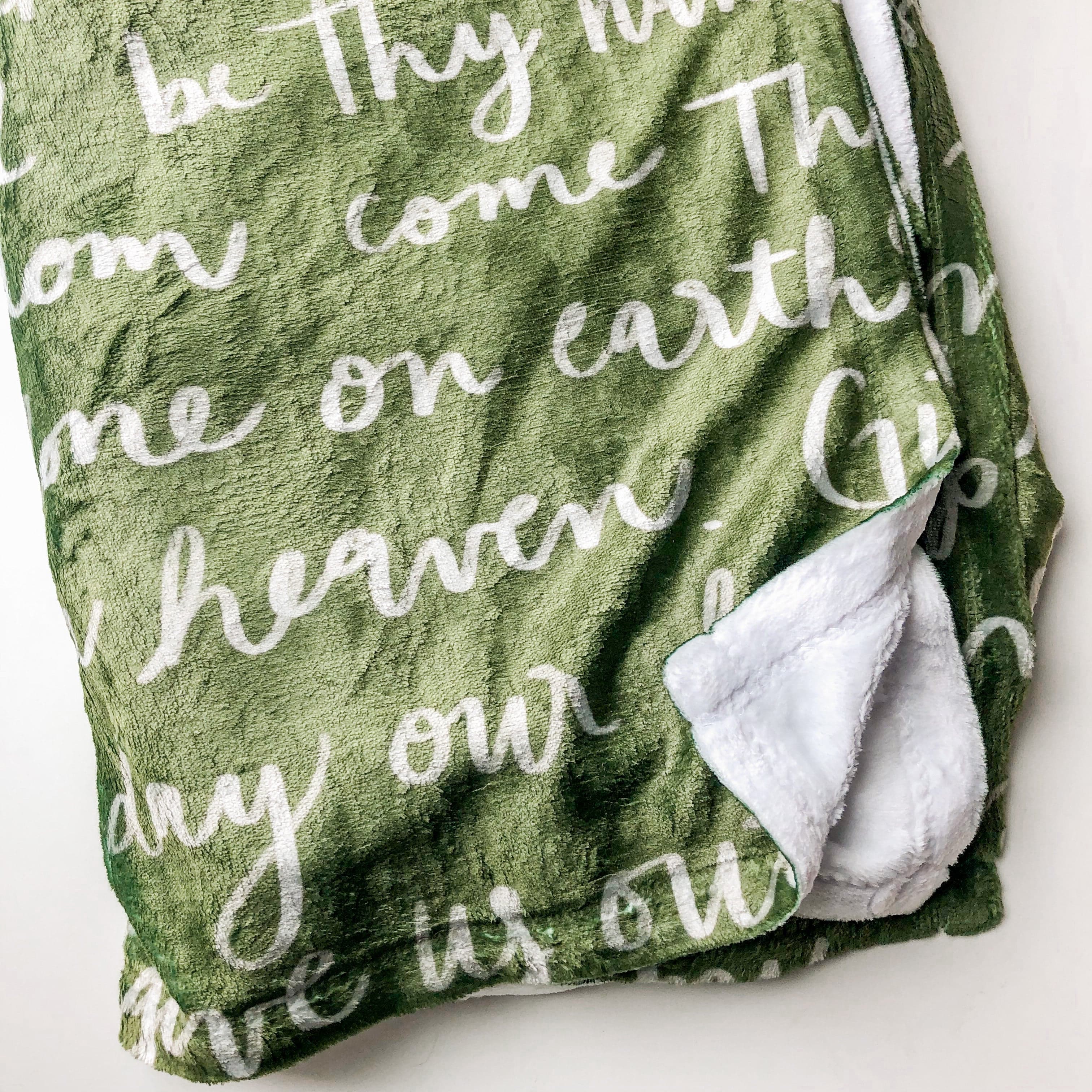 Green blanket with Give us our day text.
