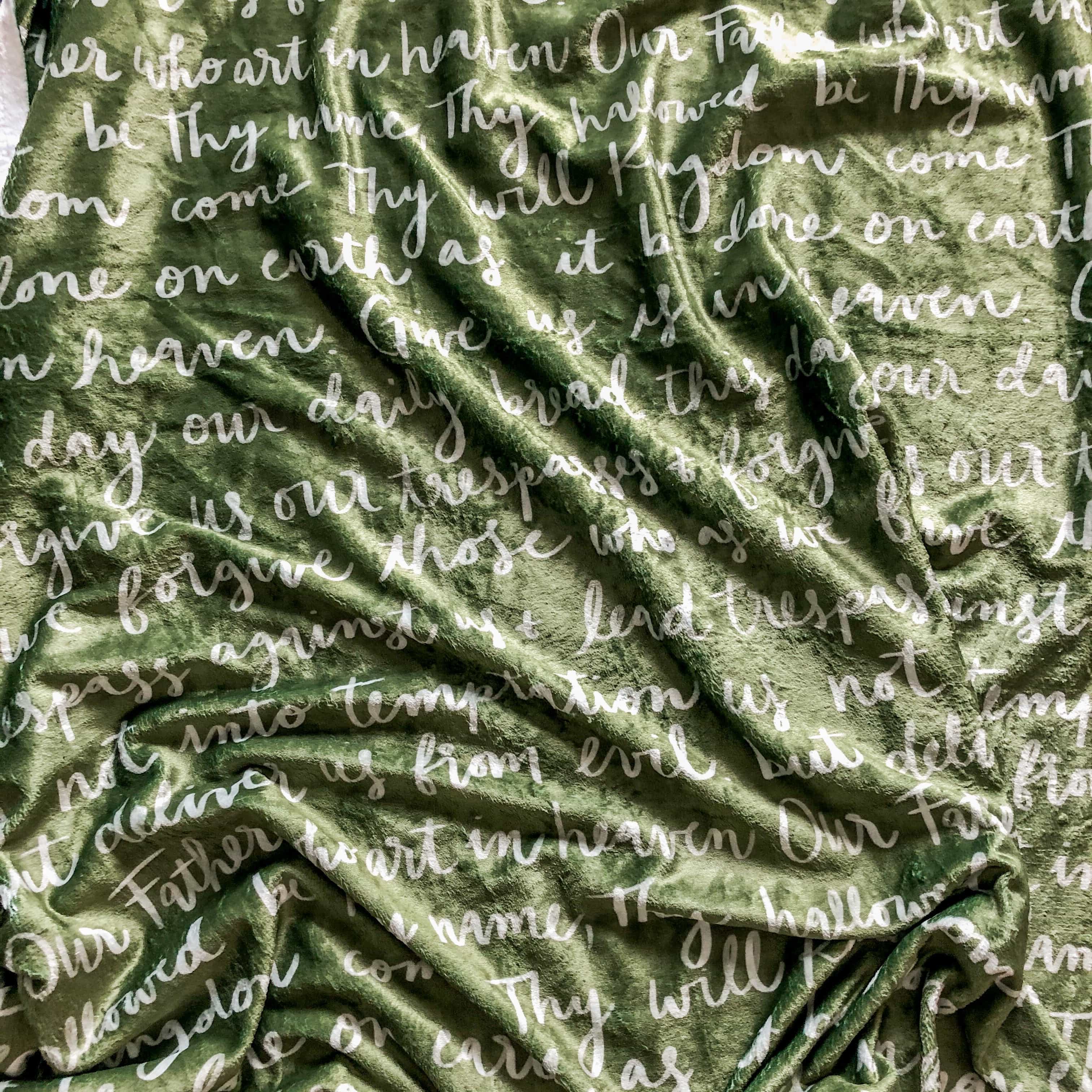 Green blanket with the Lord's Prayer written on it