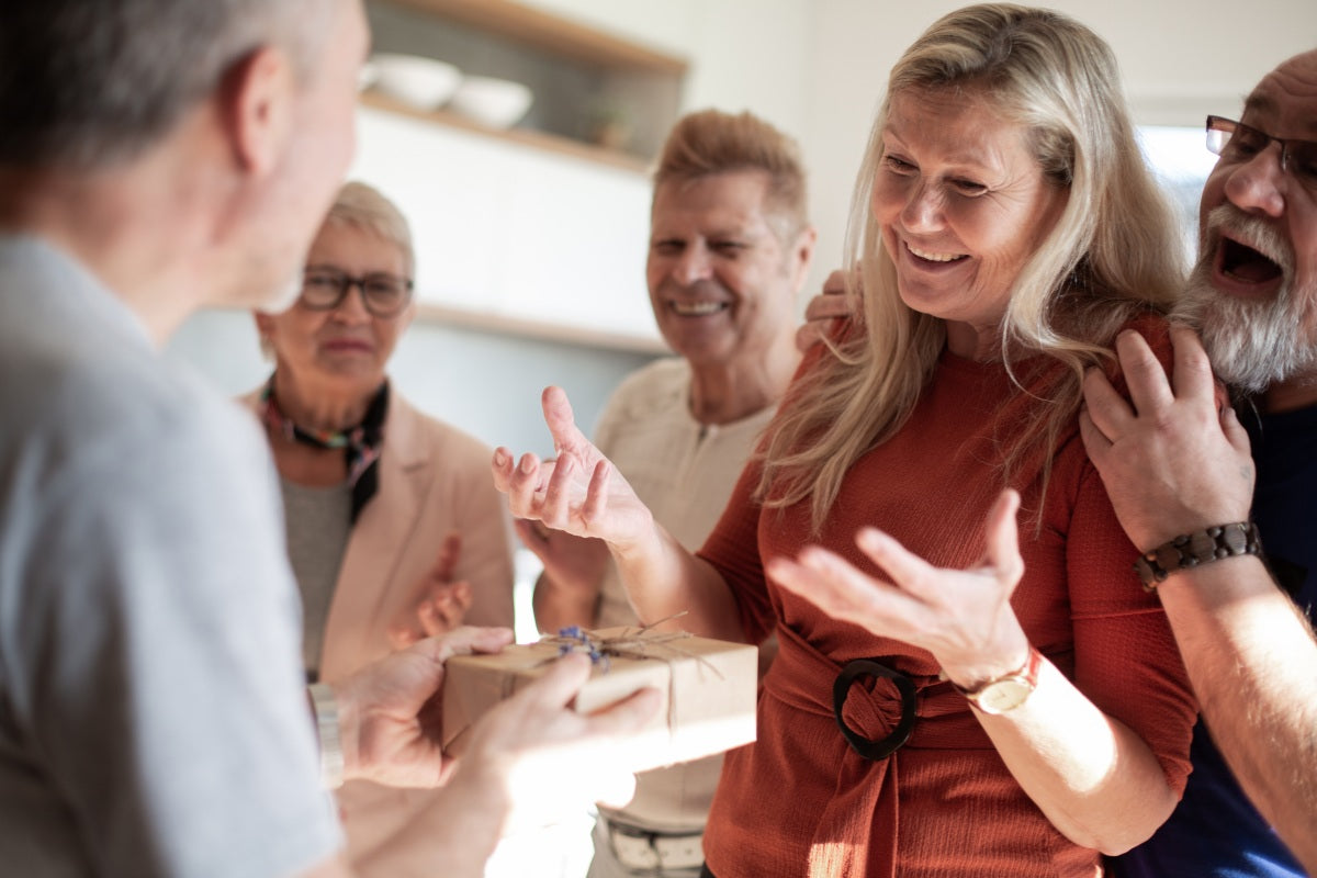Family gifting the best Christian gifts for women to a grinning family member