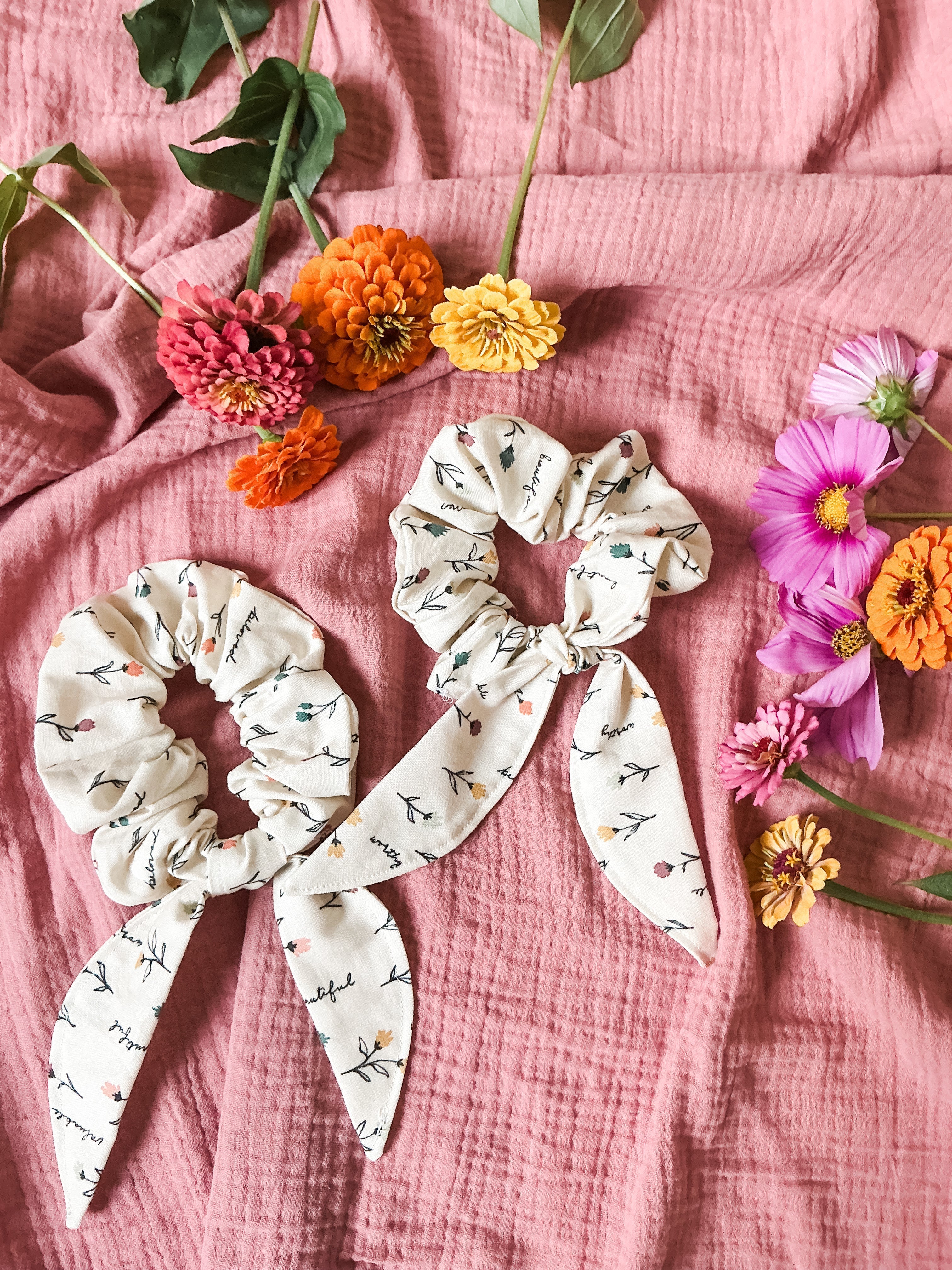 Finished bow hair scrunchie made with Beloved Wildflowers Catholic fabric, displayed on a neutral background.
