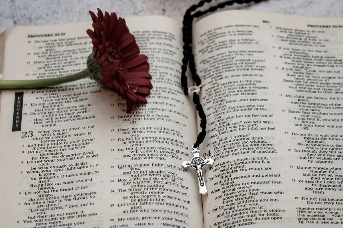 simple Rosary inside the seam of an open Bible to show what the significance of the Rosary is