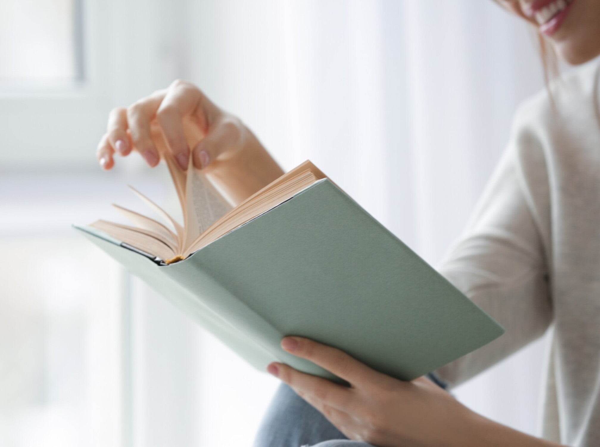 woman smiling while she reads one of the best prayer books