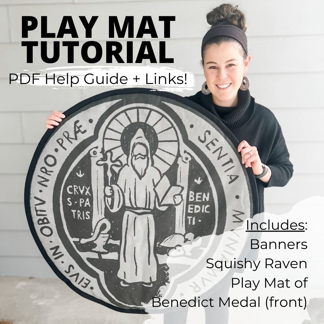 woman holds up a play mat with an image of St. Benedict