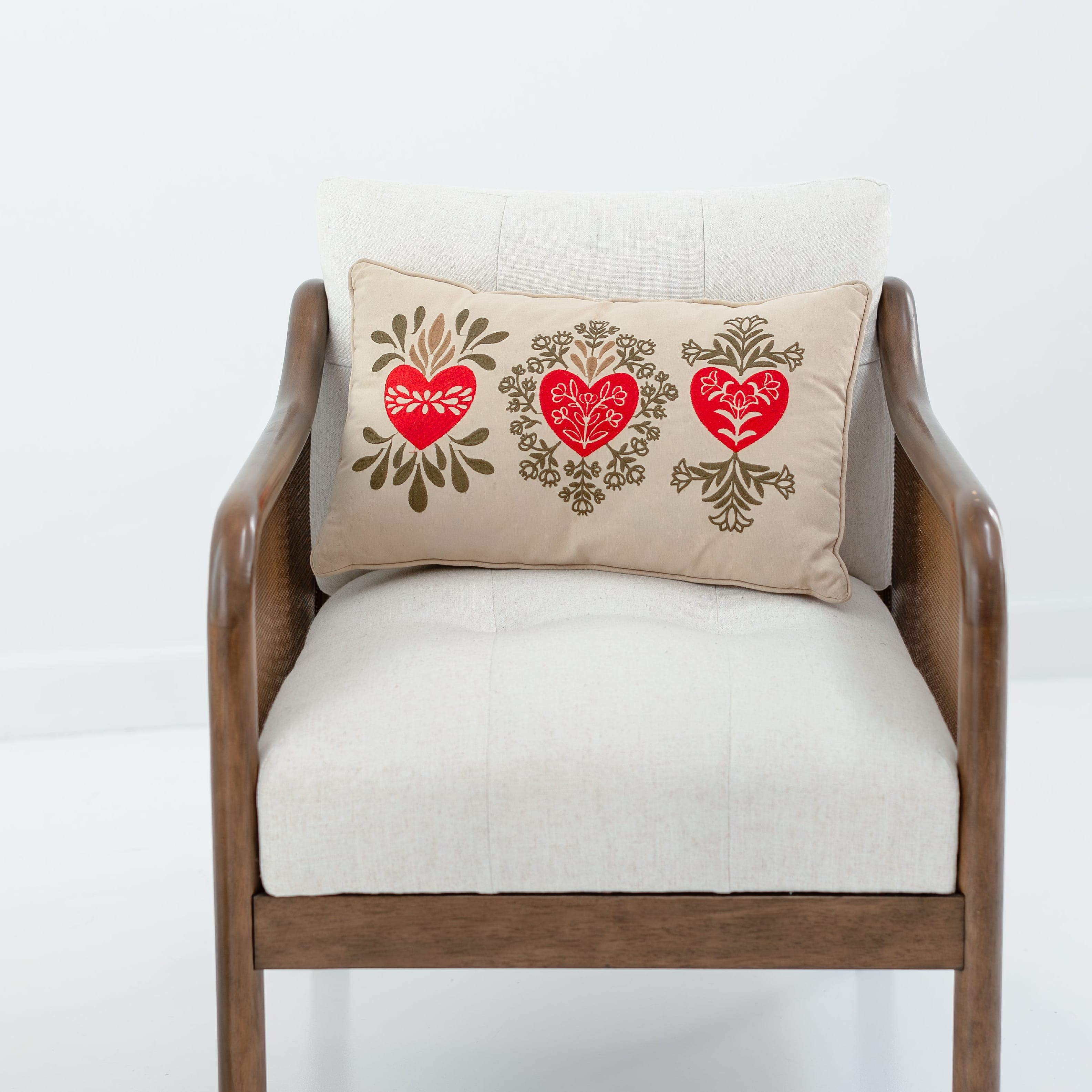 Chair with a decorative pillow featuring hearts on a white background