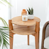 Wooden side table with a candle, vase, and plant on a white background