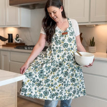 Woman in Blue Apron holding a bowl in the kitchen