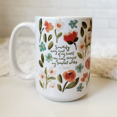 White mug with floral design and quote.