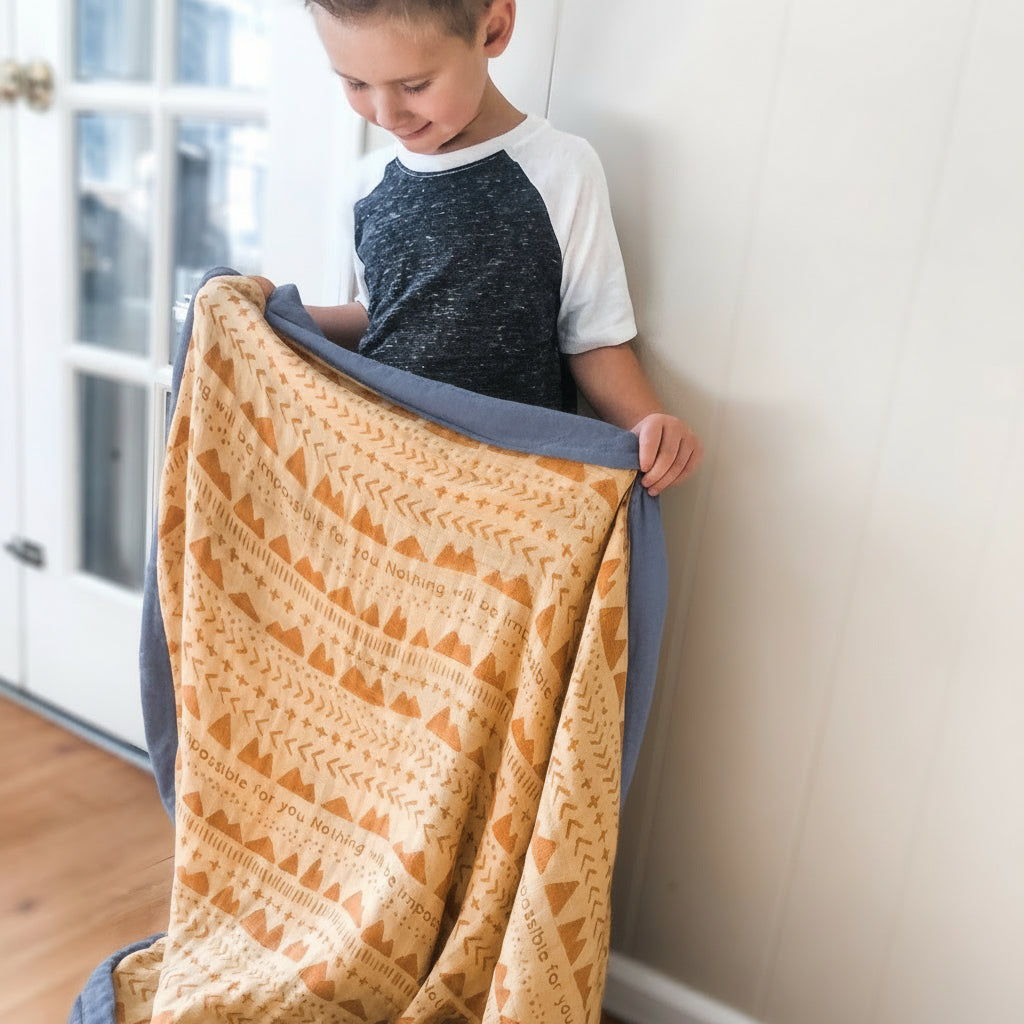 Boy holding blanket with geometric pattern