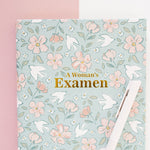 Floral notebook titled 'A Woman's Examen' on a pink and white background