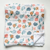 White floral blanket with folded corner.