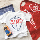 White t-shirt and red cape with angel wings.