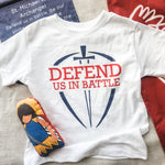 White t-shirt with Defend Us In Battle graphic.