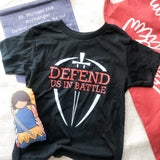 Black t-shirt with Defend Us in Battle graphic.