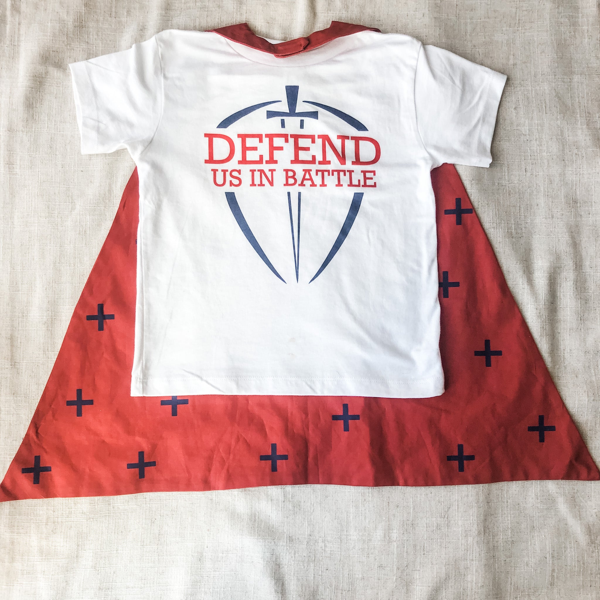 White shirt and red cape with cross symbols.