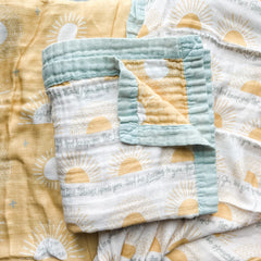 Folded baby blanket with sun print.