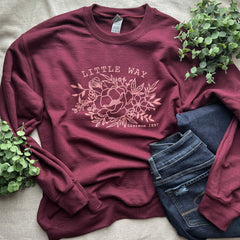 Maroon sweatshirt with floral design and jeans.