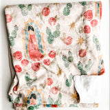 Blanket with Virgin Mary, cacti, and flowers.