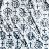 White fabric with repeating religious symbols.