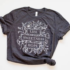 Gray t-shirt with floral design and text.